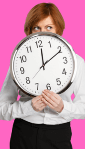 woman holding a clock with just her eyes and lower body showing. The clock reads 10 past 12. 